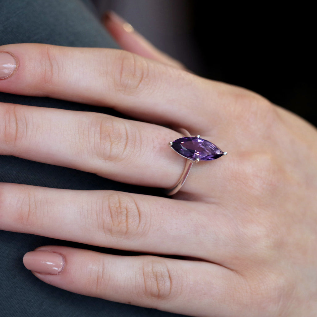 Statement ring in sterling silver featuring a big natural amethyst of marquise shape worn by a lady. Find this modern one-of-a-kind ring and other unique pieces of jewelry at our jewelry store in Montreal, or at our online store.