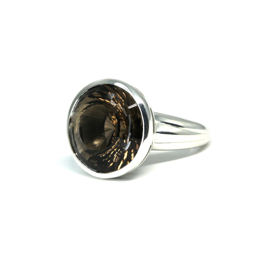Beautiful cocktail ring or statement ring in sterling silver with a stunning mysterious round shape smoky quartz. Find this gemstone ring at Ruby Mardi, a fine jewelry store located in Montreal's little Italy, close by Rosemont, Outremont, Mile-End, Mile-Ex and Villeray. We sell the work of talented young Canadian Jewelry designers. We offer engagement rings and custom jewelry services in Montreal.