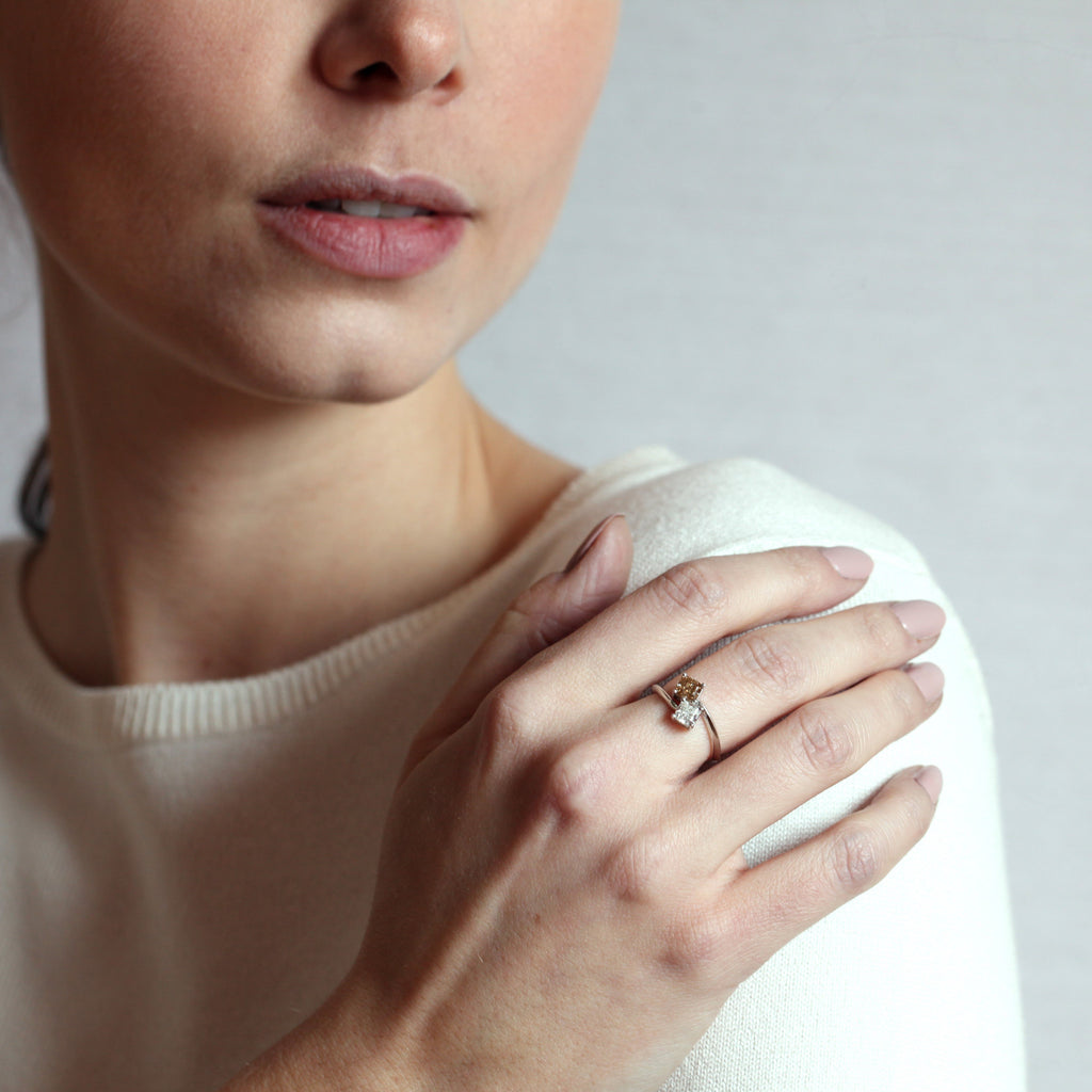 girl wearing a toi et moi diamond white gold custom made ring in montreal on a grey background