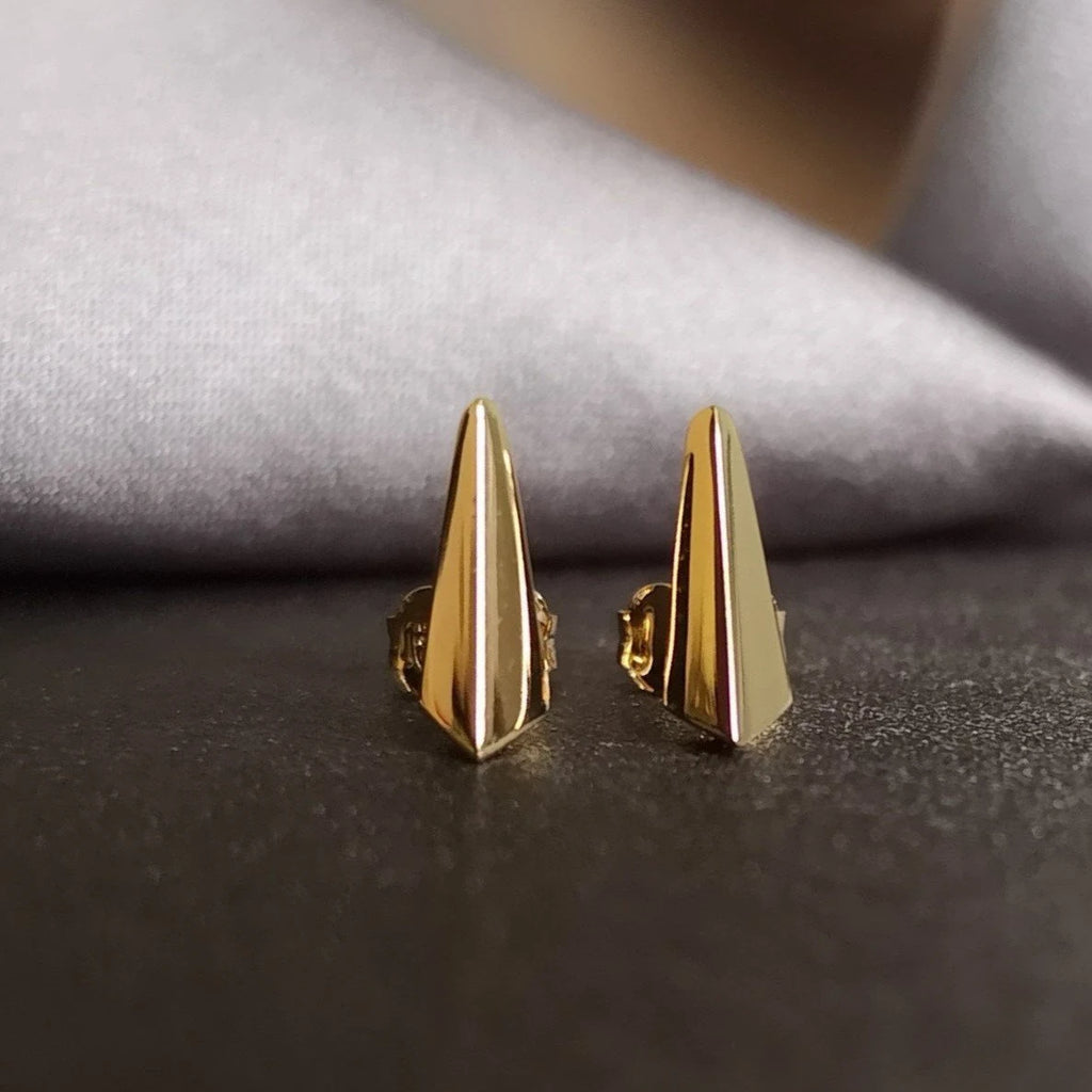 front view of vermeil gold minimalist stud earrings by bena jewelry designer montreal for boutique ruby mardi jeweler in little italy on a dark background
