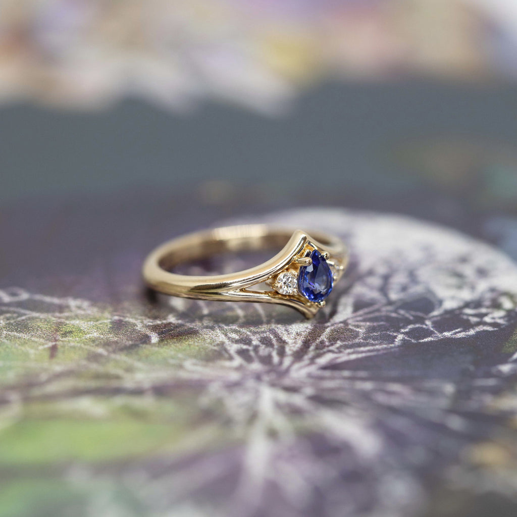 Adorn ring by Bena Jewelry : yellow gold version with a vivid blue sapphire and two round brilliant diamonds. A custom made bridal ring.