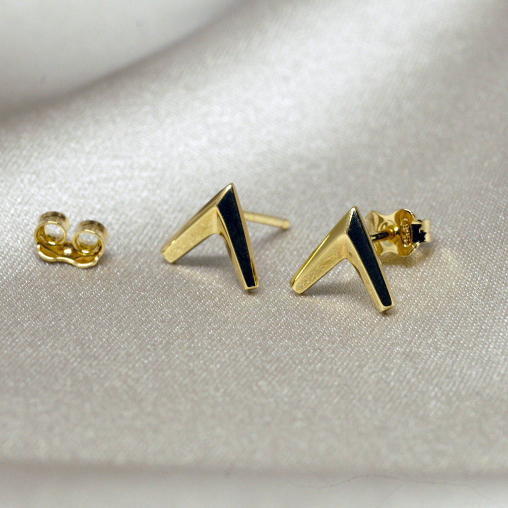 Simple gold vermeil arrow earrings in V shape on a satin background. Unisex jewelry pieces for parties and for everyday wear. Available online or at our Montreal's Little Italy store, with the work of other jewelry designers. We also offers custom jewelry services in Montreal.