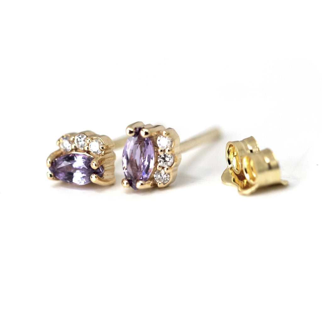 Lilac Violet Sapphire Earrings with 3 diamonds on a white background. Sapphire gemstone stud gold earrings created by Ruby Mardi, a fine jewelry store in Montreal's Little Italy, close by Outremont, Rosemont, Villeray and Mile End districts. We specialize in engagement rings, gold jewelry, heirloom jewelry, bespoke, custom jewelry creation in Montreal. We can source ethical gemstones, natural diamonds, lab grown diamonds, Canadian Diamonds. We sell the work of the most talented Canadian jewelry designers.