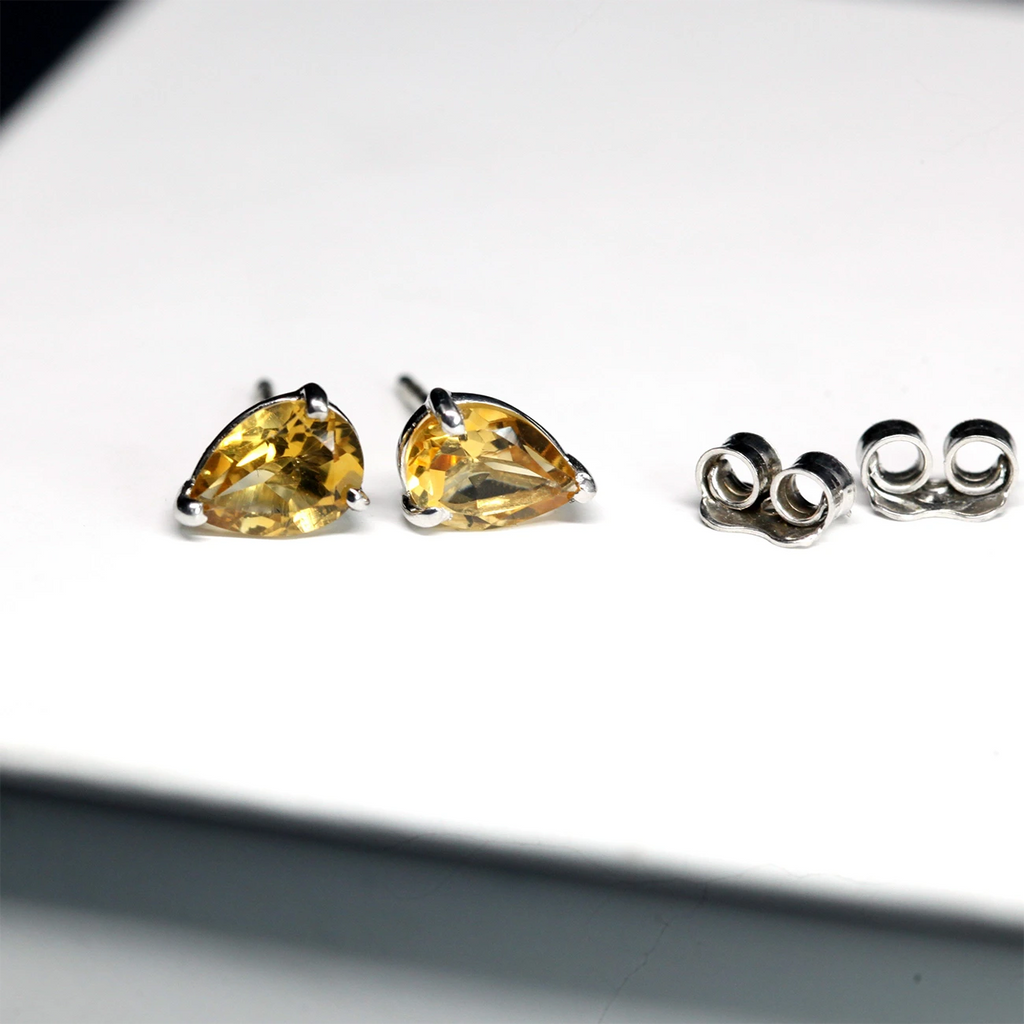 top view of citrine gemstone pear shape silver stud earrings made in montreal designer artisan ruby mardi villeray little italy on a white background