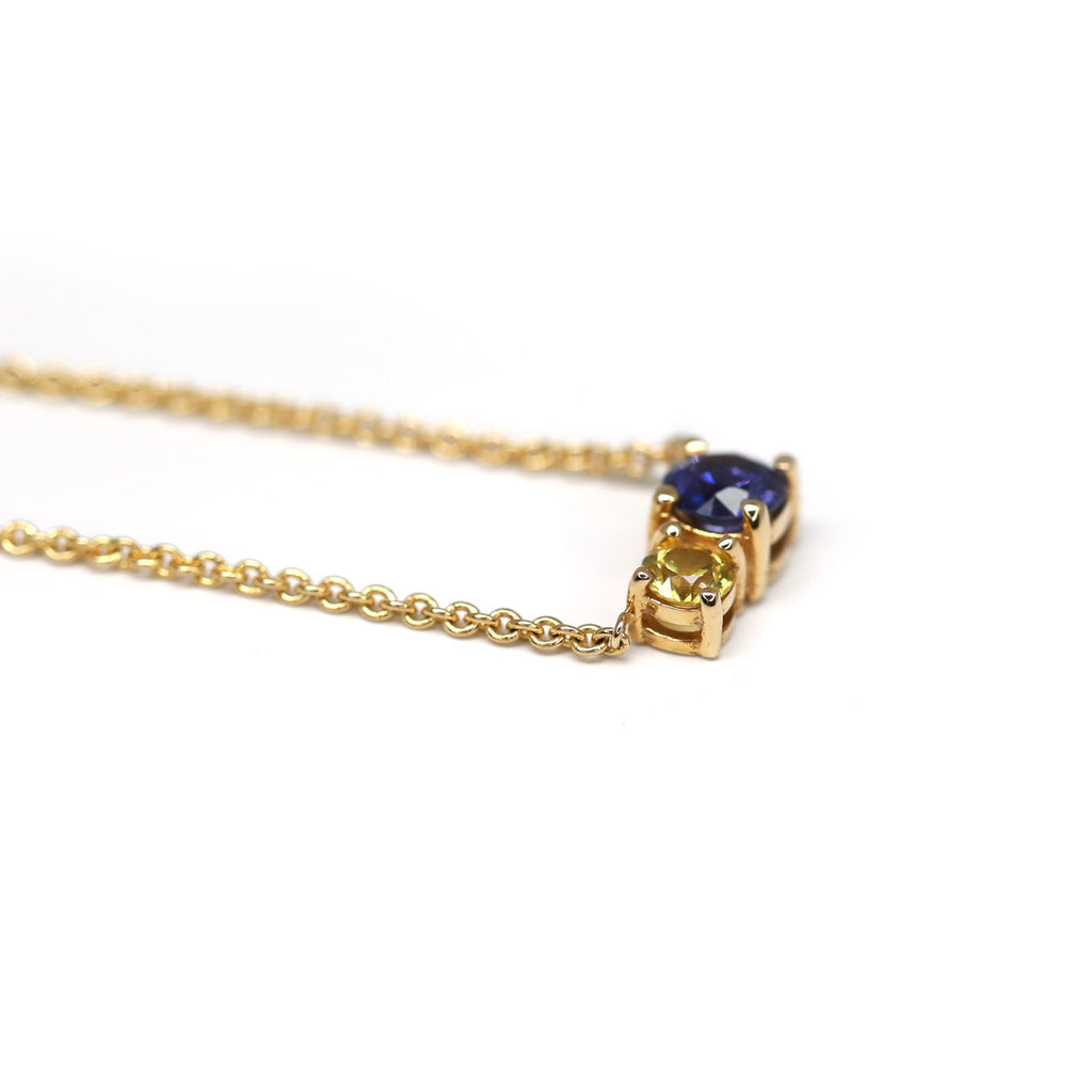 Le collier en or jaune Royal Mimosa fabriqué à la main par Lico Jewelry à Montréal présente un saphir bleu et un saphir jaune. Il est disponible à la bijouterie Ruby Mardi, dans la Petite Italie. Nous offrons aussi des services de création de bijou sur mesure.