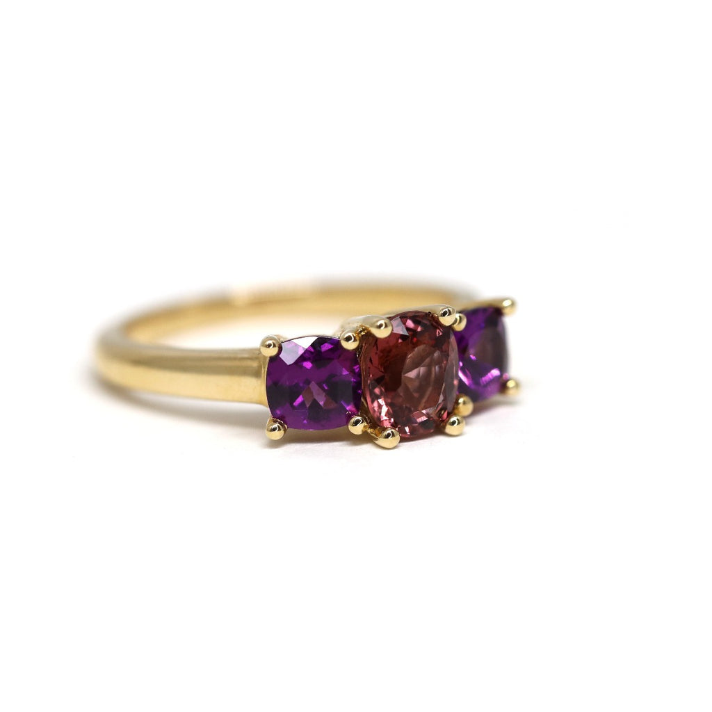 Side view of a gold engagement ring or right hand ring by Lico Jewelry. Ring featuring an orange spinel and two purple rhodolite garnet. Find her stunning colorful work at Ruby Mardi, a one-of-a-kind jewelry store showing the work of the best Canadian jewelry designers. 