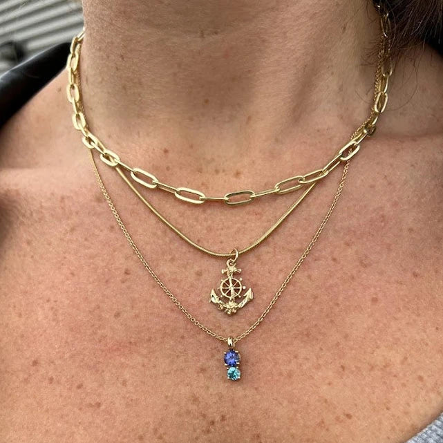 girl wearing small colored gemstone blue zircon and tanzanite gems on yellow gold pendant and chaine white couple other fine chaines avialable at boutique ruby mardi montreal best jeweler by lico jewelry