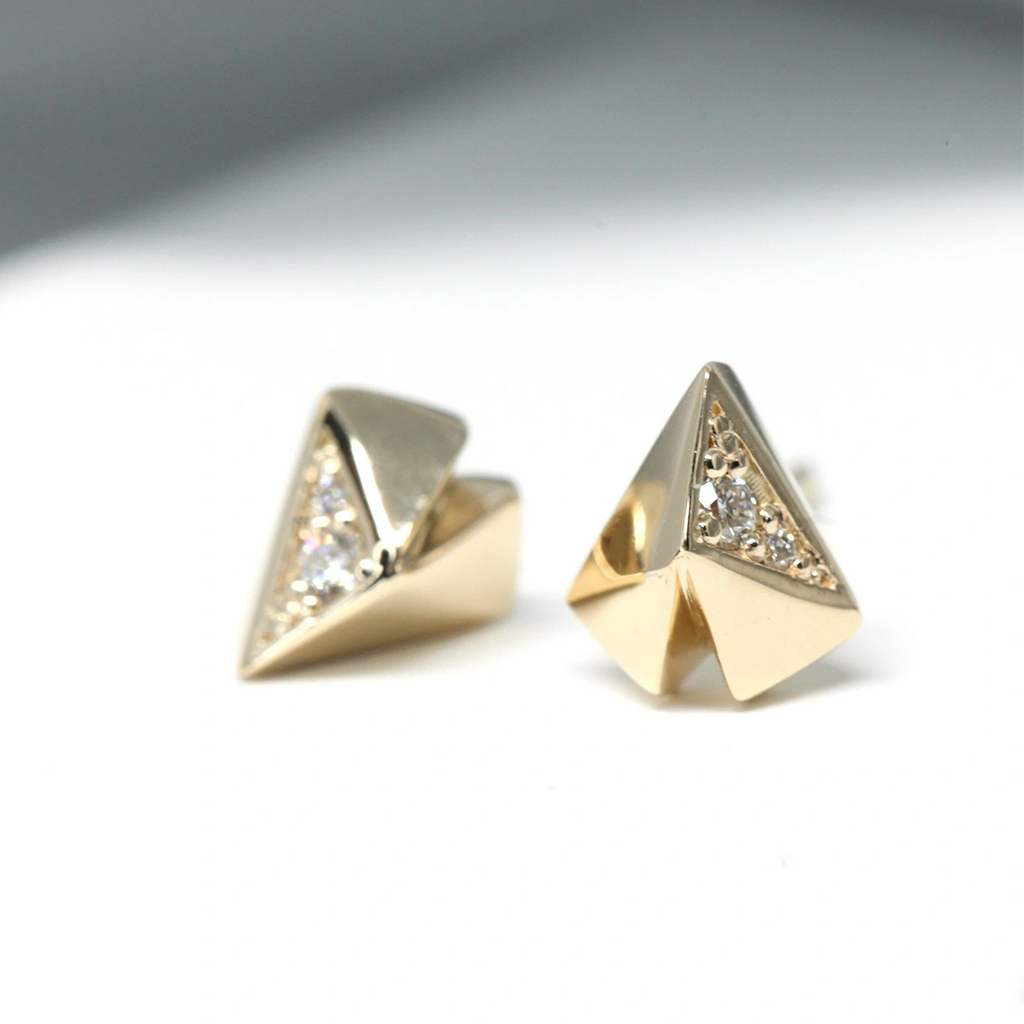 Front close up view of a pair of yellow gold diamond stud earrings that are custom made by fine jewellery designer Bena jewelery. They are seen on a white background with a shadow.