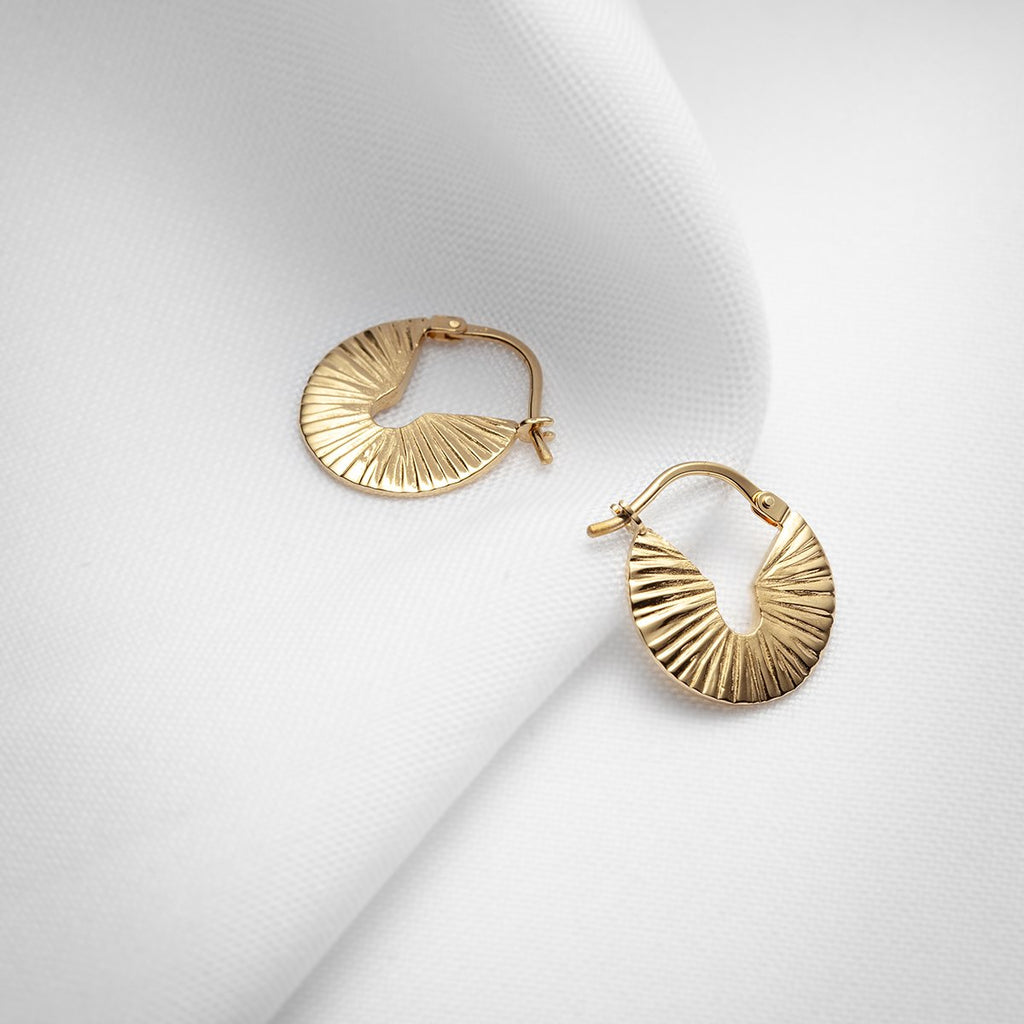 Small but chunky round textured gold vermeil hoops handmade in Montreal by Veronique Roy JWLS. Available at jewelry store Ruby Mardi, in Little Italy.