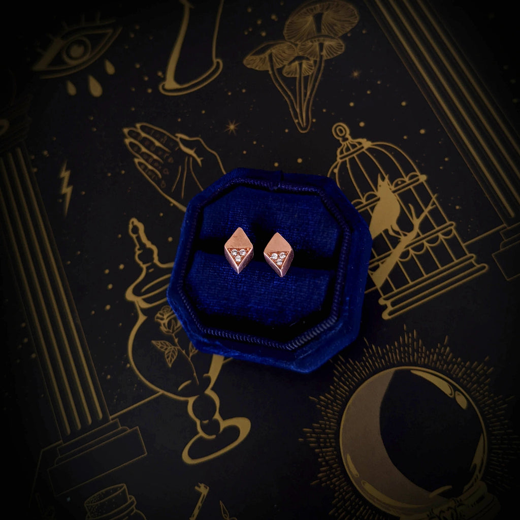 top view of diamond rose gold earrings studs by liane vaz montreal retailer boutique ruby mardi montrreal finest jewellery gallery in montreal in a blue jewellery box and a dark background