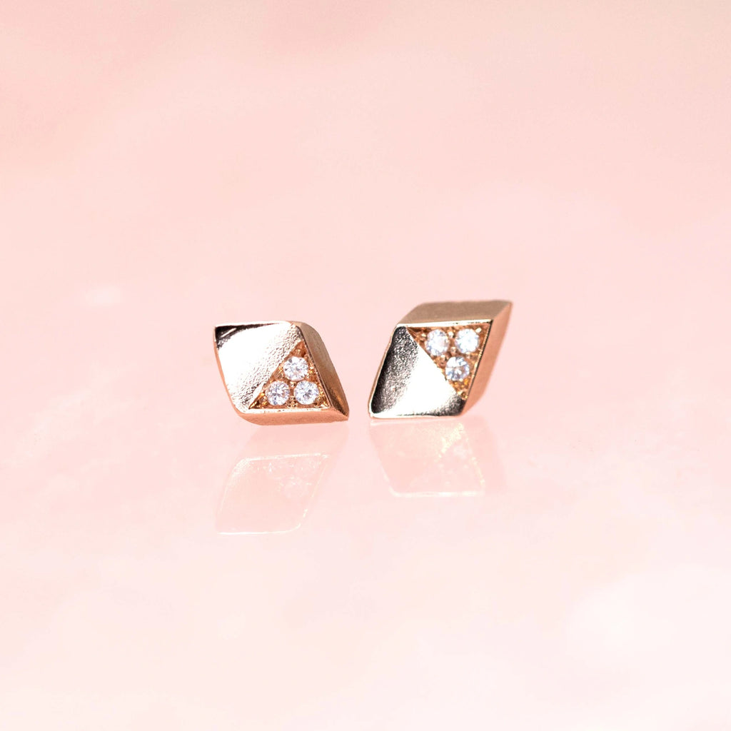 side view of rose gold diamond stud earrings by liane vaz montreal jewellery designer fine edgy jewellery designer at boutique ruby mardi on a pink background