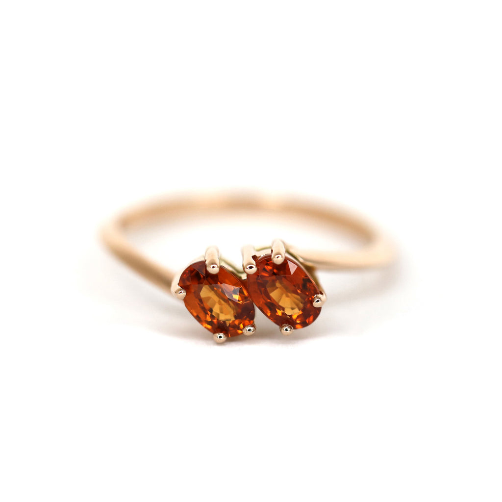 Product photography of a toi & moi spessartite garnet ring in rose gold by designer Bena Jewelry. The perfect symbolic engagement ring. Find the most exquisite designer jewelry at Ruby Mardi, a fine jewelry store in Montreal that presents the work of the most talented Canadian jewelry designers. Custom jewelry services also offered.