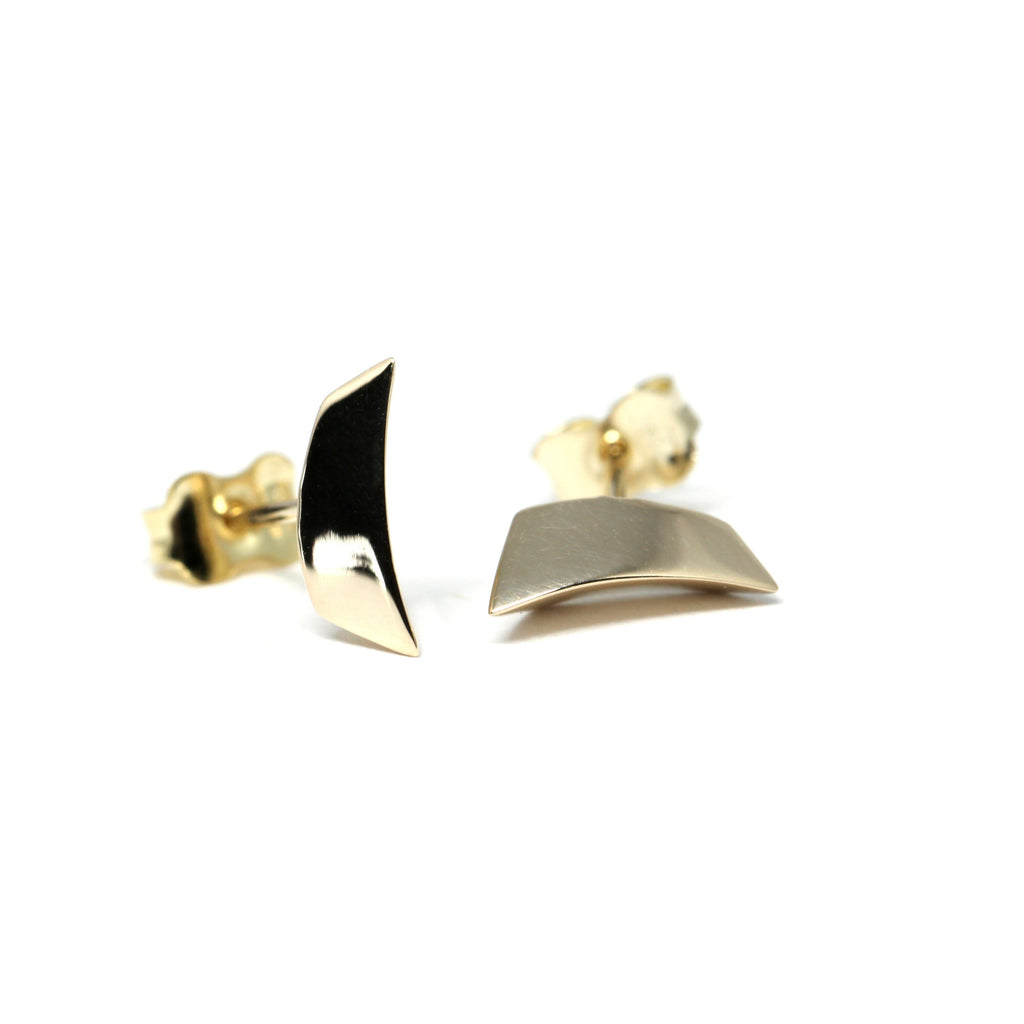Edgy yellow gold stud earrings with a sculptural curved design, crafted in Montreal by Canadian designer Bena Jewelry. These unisex earrings are available at Ruby Mardi, a contemporary jewelry boutique in Montreal.