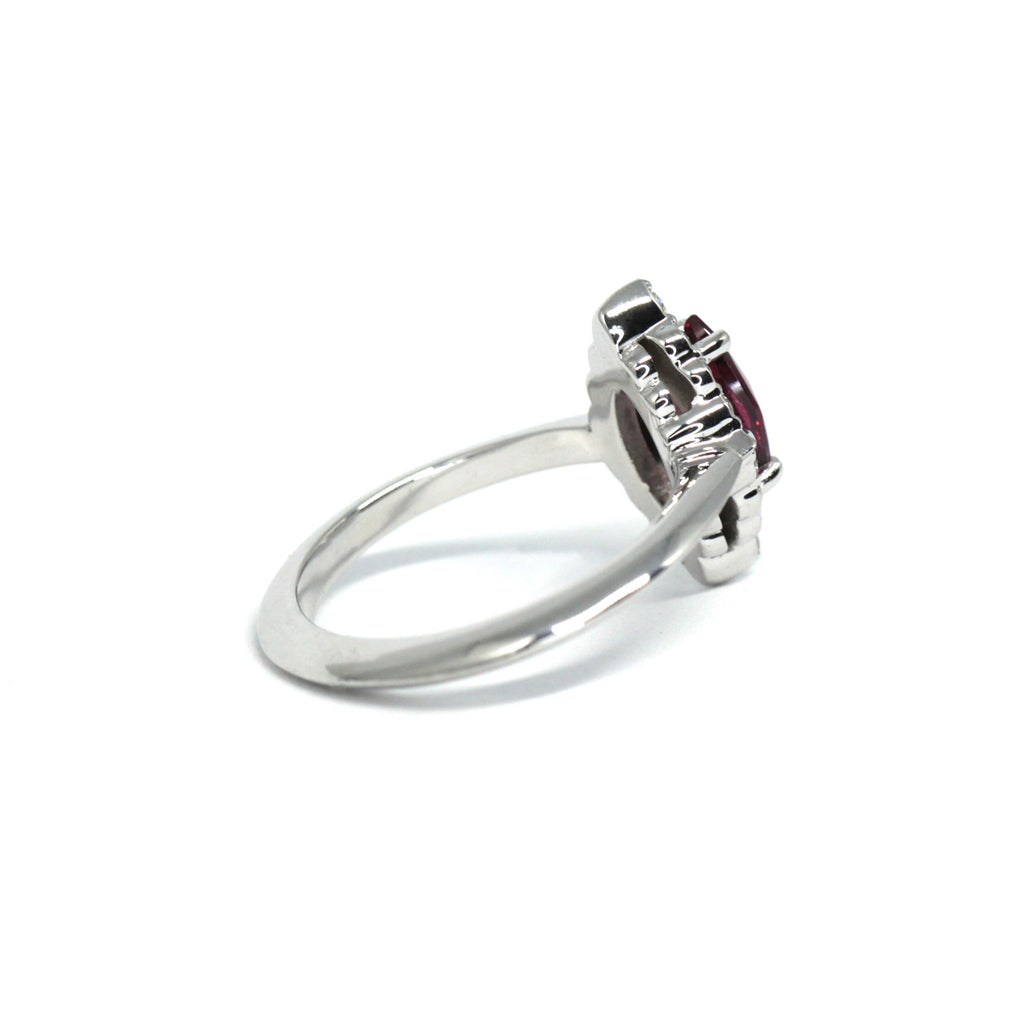 Side view of a red garnet with diamond halo engagement ring. Find more fine jewelry pieces at our high end jewelry store in Montreal’s Little Italy.