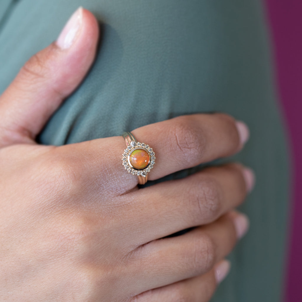 Fashion shot of the amazing ELENA: a yellow gold ring with a cognac diamond halo and a central orange opal by designer Bena Jewelry. Modern designer jewelry available at Ruby Mardi, the only fine jewelry gallery in Montreal. Custom jewelry services also offered.