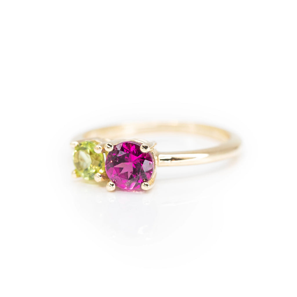 side view of round purple garnet and peridot toi et moi minimalist engagement ring custom made in montreal by lico jewelry on a white background