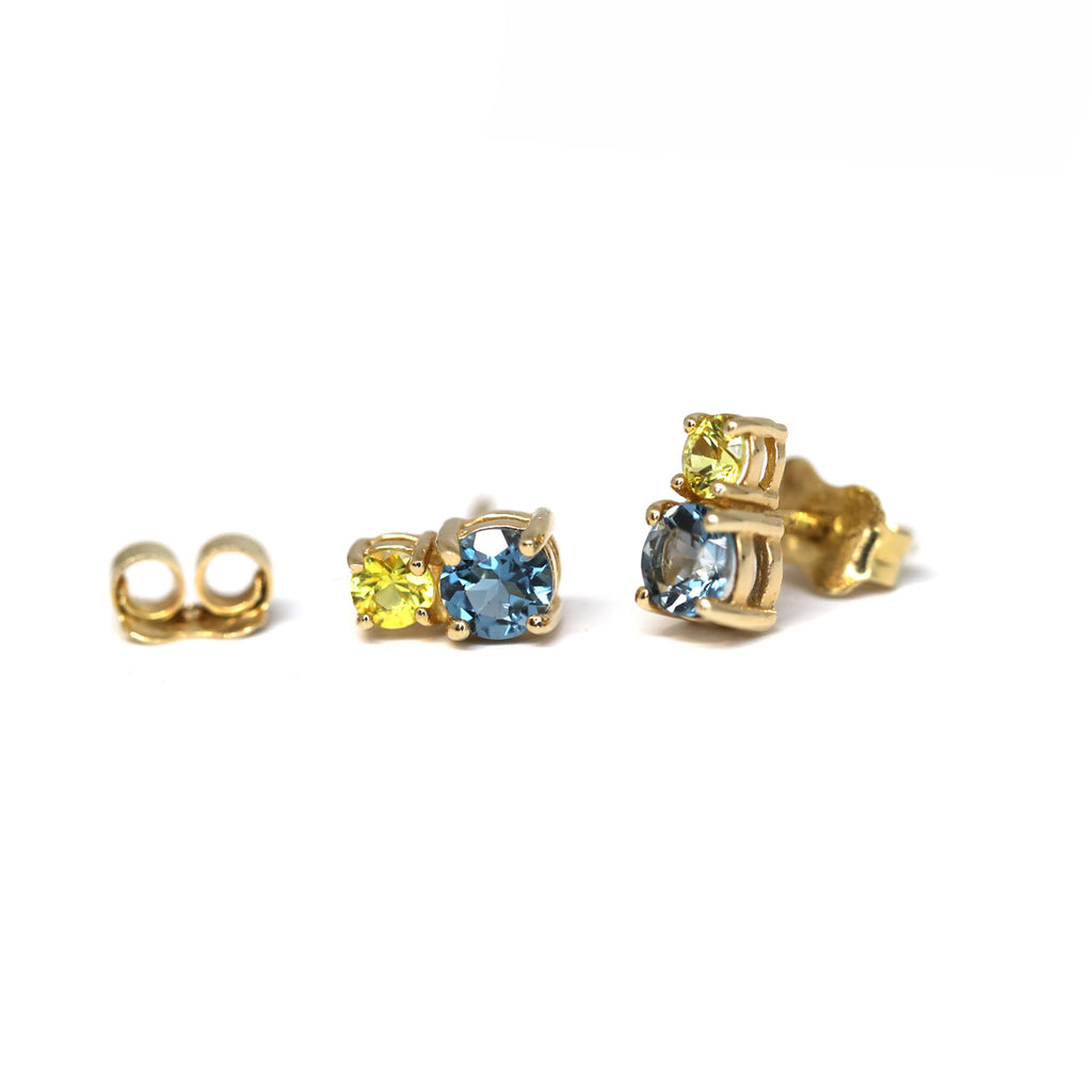 Gold gemstone stud earrings featuring yellow sapphire and Swiss Blue Topaze. Jewelry available at high end concept store and gallery Ruby Mardi.