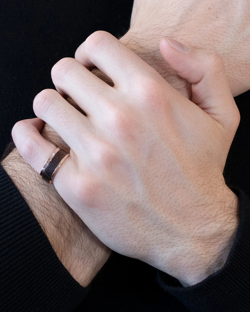 men wearing on the pinky a wood and rose gold men ring wedding band custom made in montreal by Janine de Dorigny finest jewellery store boutique ruby mardi on a dark background