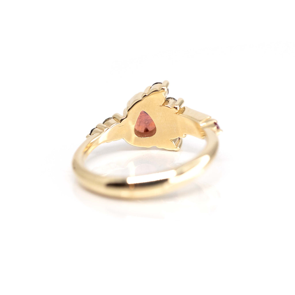 A beautiful ring by Nadia Werchola featuring amorphous red rose cut sapphire, black diamonds, salt & pepper diamonds, ruby and black spinel, set in 10k yellow gold and photographed from back.