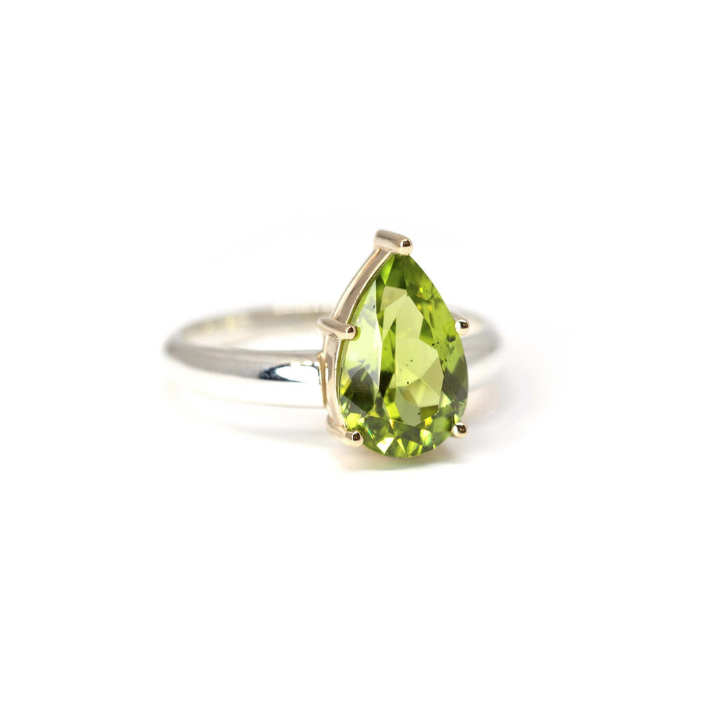 Huge peridot green gemstone statement ring on a white background photographed in close-up. Ready-to-wear fashion jewelry available online or at our concept store in Montreal's Little Italy, along with the work of other talented jewelry designers. 
