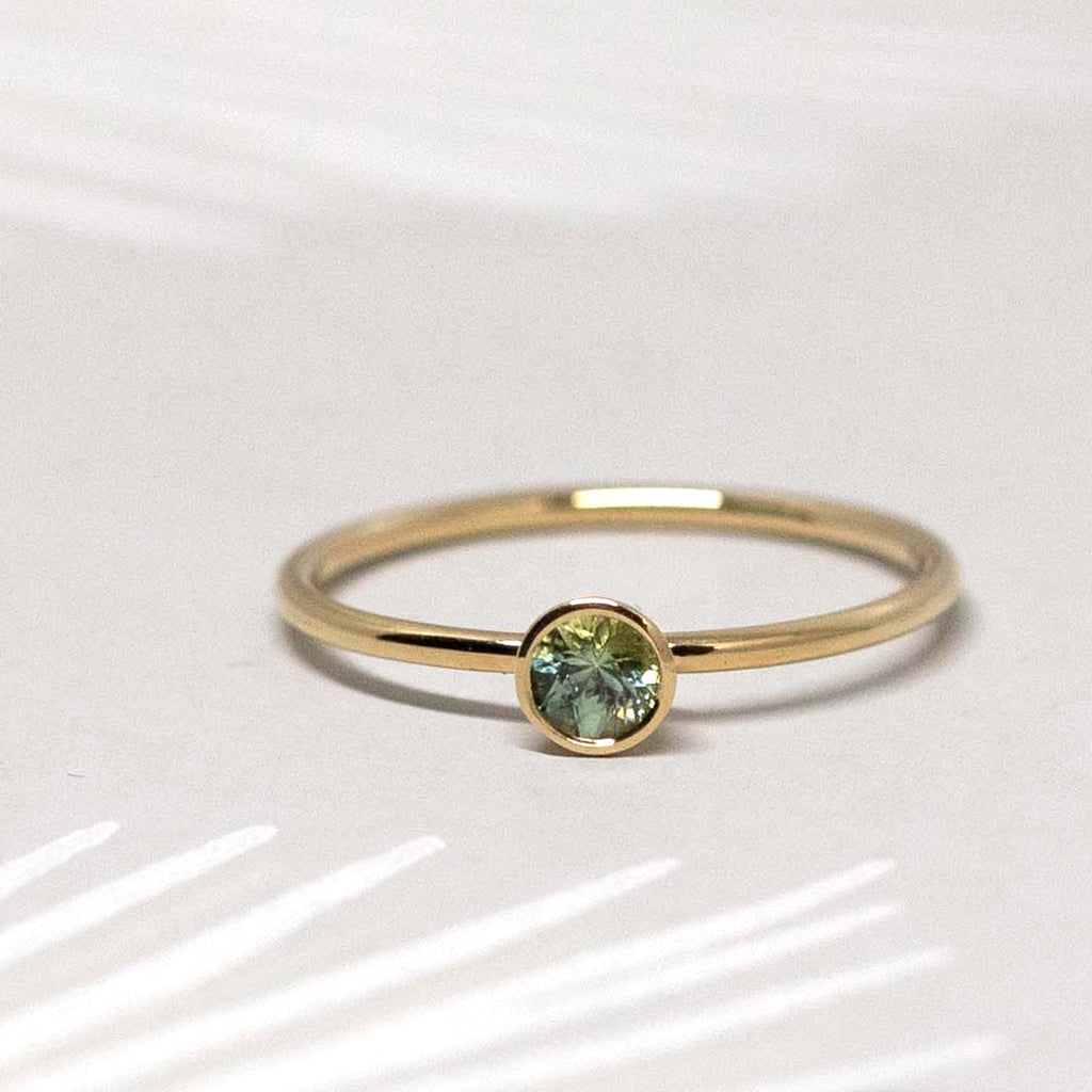 Gold Ring with green sapphire from collection Les Ardents showing a hidden heart at the back of the rings, fine jewelry pieces handmade by Montreal jewelers C'est pas moi, c'est ma soeur. Find more designer jewelry at Ruby Mardi, a fine jewelry gallery in Montreal's Little Italy. We specialize in engagement rings and offer custom jewelry services in Montreal. We offer exquisite ethical gemstones, Canadian diamonds, natural diamonds, lab grown diamonds.