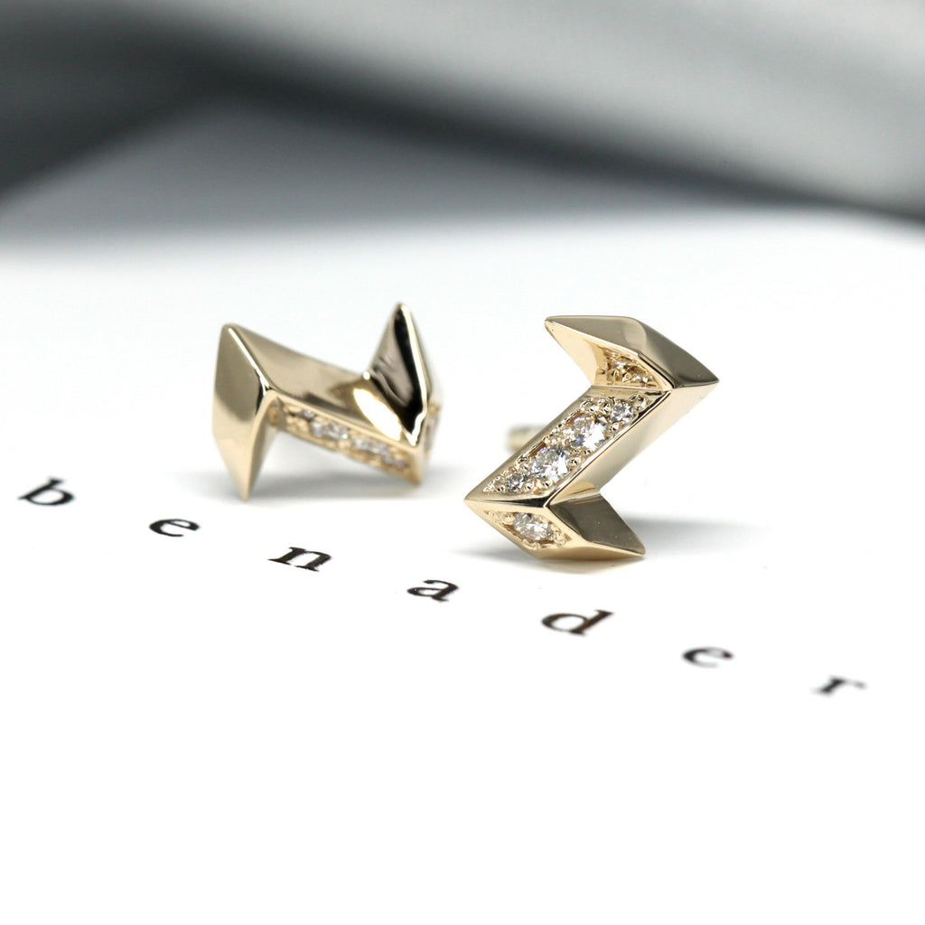 yellow gold diamond small stud earrings fine jewelry design montreal at ruby mardi little italy jewellers artisan edgy studs on a grey background and bena written on a white background