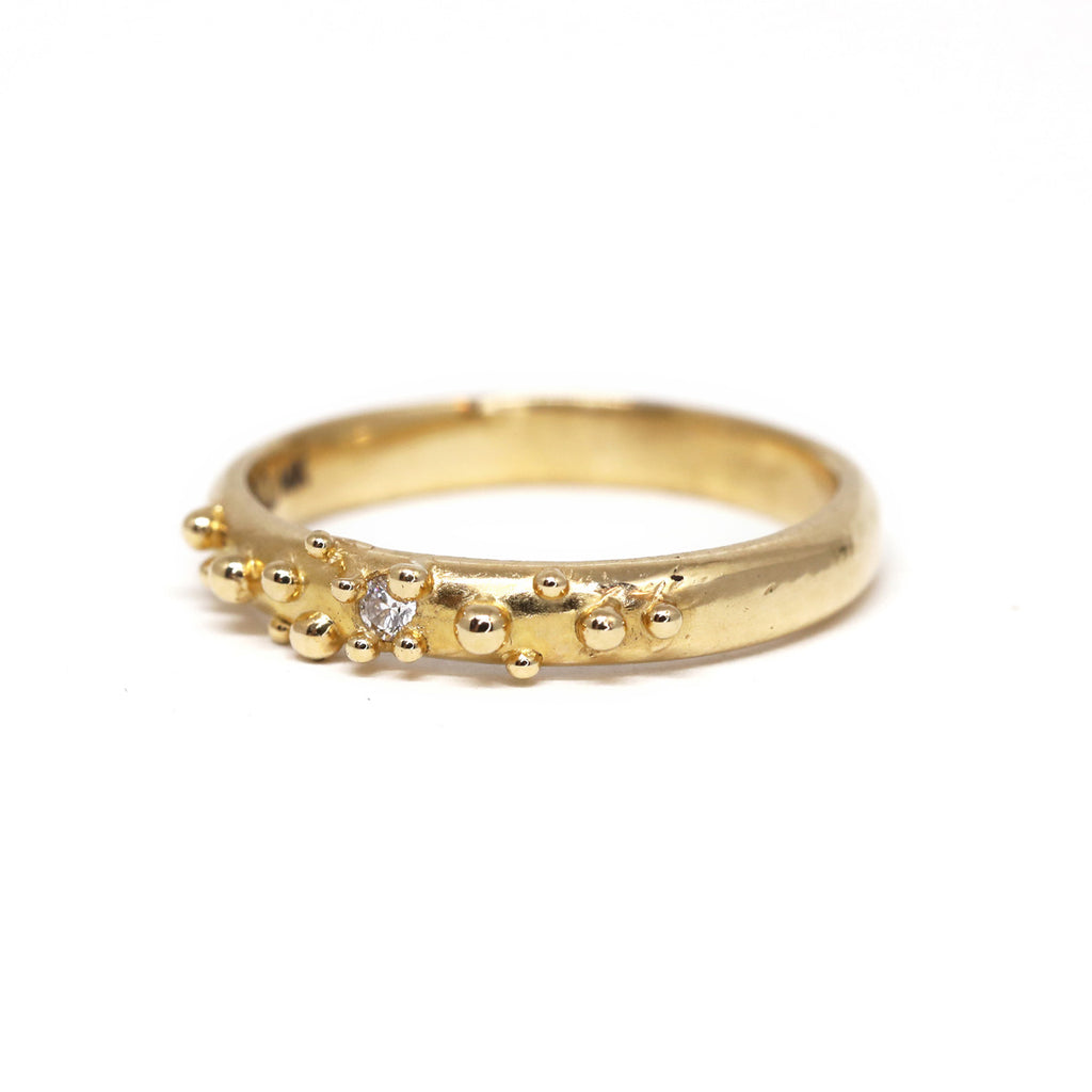 Yellow gold Baleal wedding band with a round brilliant diamond by Toronto-based jewelry designer Meg Lizabet. Organic ring with hand-placed gold granules. 14K yellow gold ring, original wedding band or engagement ring. Unique one-of-a-kind unisex gold band. Non gendered jewelry. Find Meg Lizabet's creations in Montreal at Ruby Mardi, a boutique-gallery in Montreal's Little Italy, not far from Rosemont, Villeray, Outremont, Mile End. Custom jewelry design services in Montreal also available.