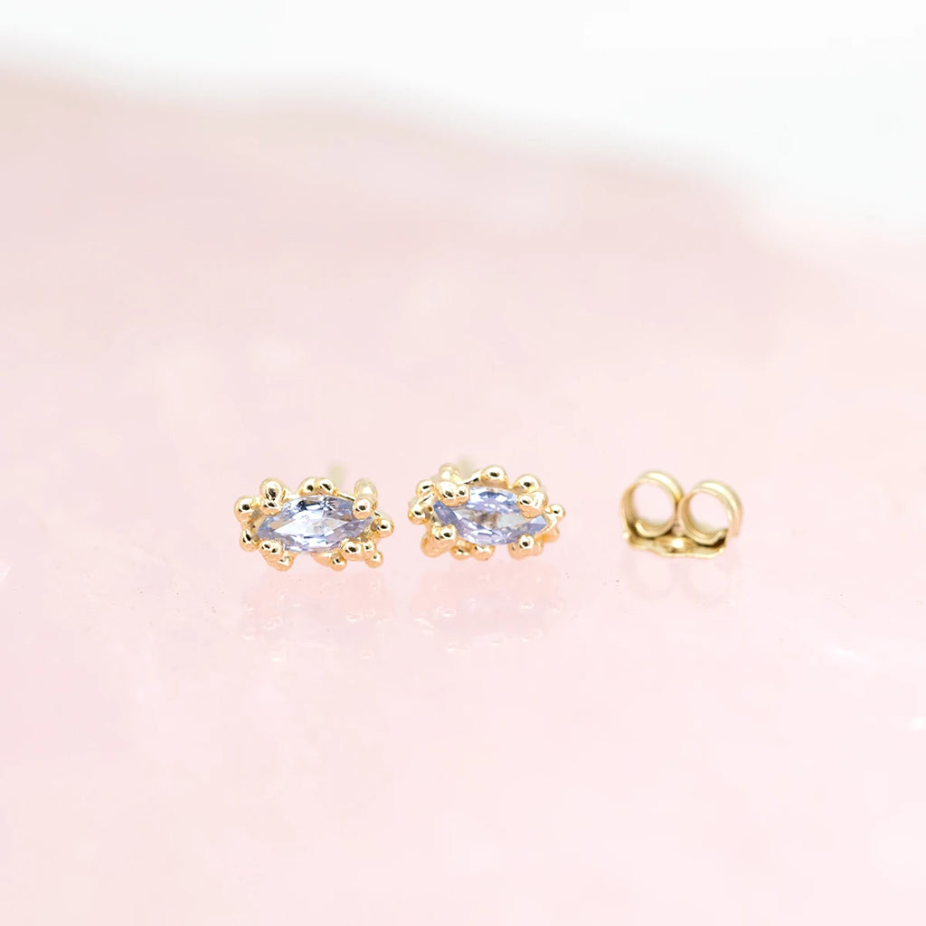 front view of marquise shape sapphire gemstone stud earrings made in montreal by the fine jewelry designer meg lizabet at boutique ruby mardi canadian jewellery designers on pink background