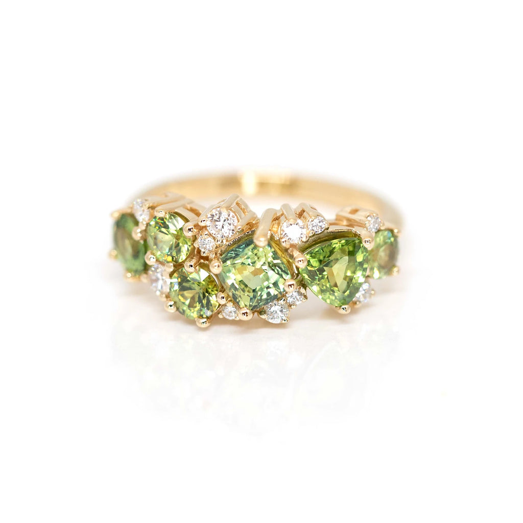 cushion and round shape green sapphire and diamond bridal engagement ring in montreal on a white background