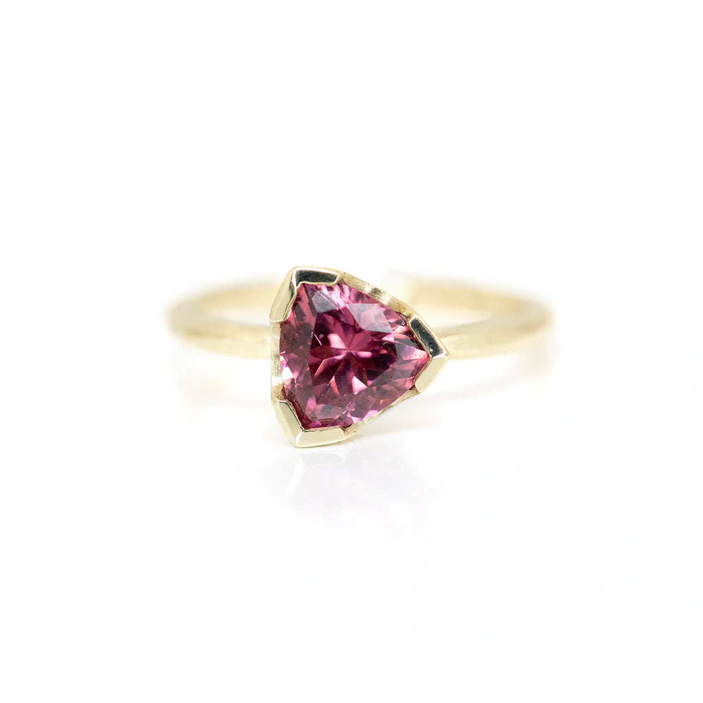 Sheena Purcell gold ring with trillion garnet dark pink reddish gemstone set in half bezel designer ring made in montreal at boutique ruby mardi on white background