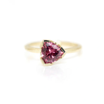 Sheena Purcell gold ring with trillion garnet dark pink reddish gemstone set in half bezel designer ring made in montreal at boutique ruby mardi on white background