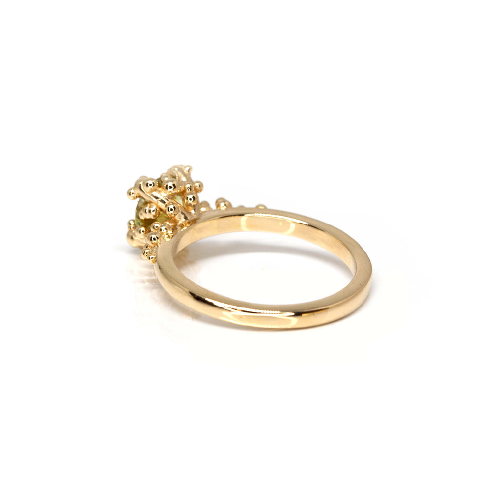 Stunning engagement ring by Meg Lizabet Jewellery photographed on a white background and seen from the back. A yellow gold organic ring with gold granules and encapsulated bicolor sapphire (yellow & green) of 1.08ct. One of a kind ring available only at Ruby Mardi.
