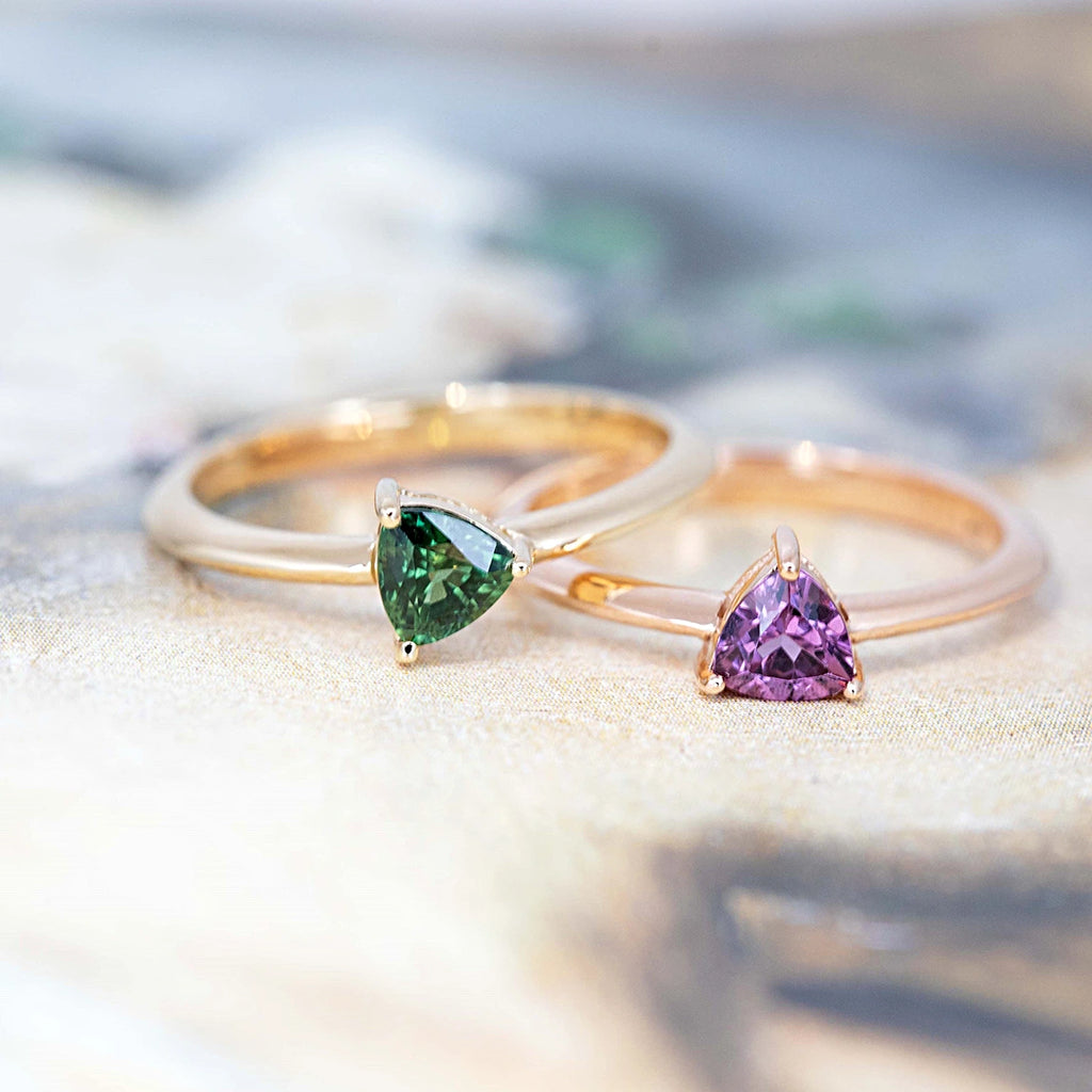 set of two custom made colored gemstone minimalist ring trillion shape purple garnet and green sapphire gold bridal ring custom made in montreal by ruby mardi designer on multi color background