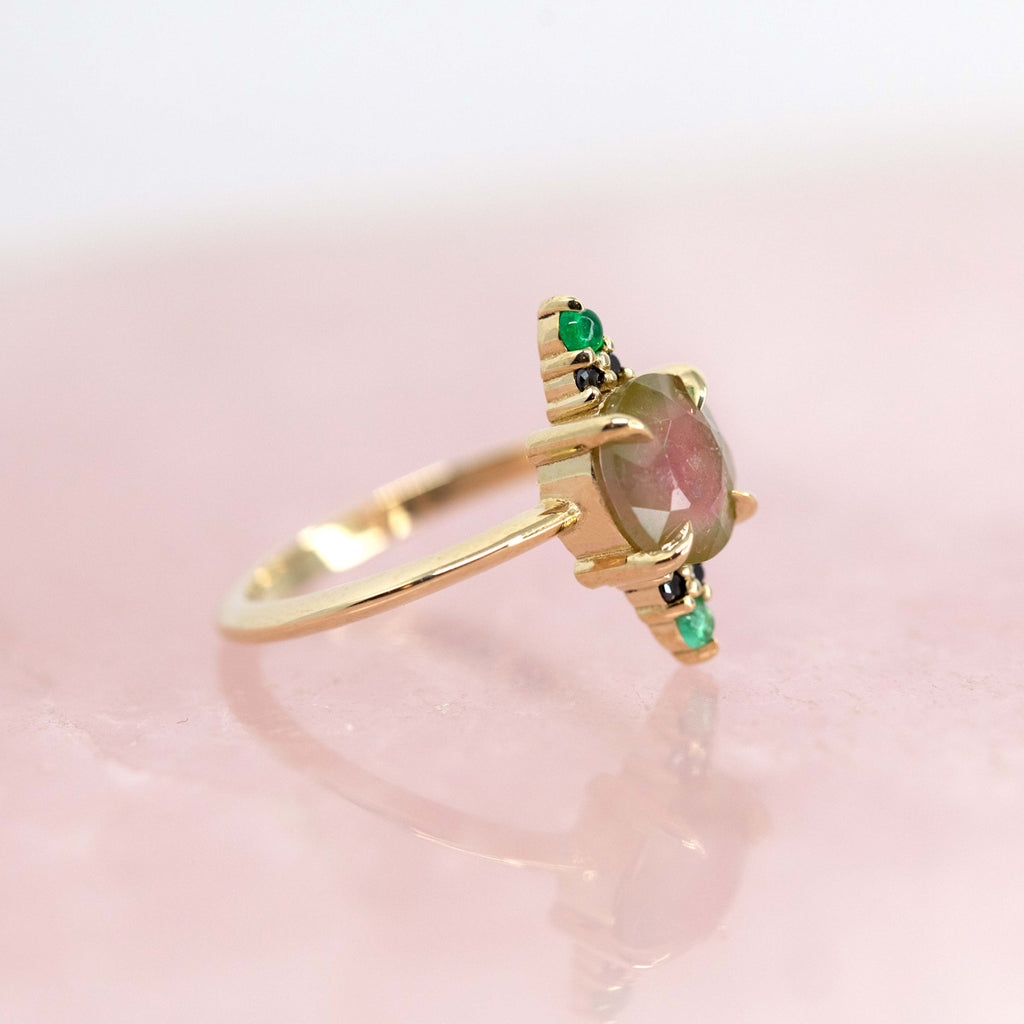 A creation from Nadia Werchola seen from the side : a yellow gold ring featuring a big central watermelon tourmaline, emerald and black diamonds. Ruby Mardi sells the work of the most talented Canadian jewelry designers in Montreal’s Little Italy.