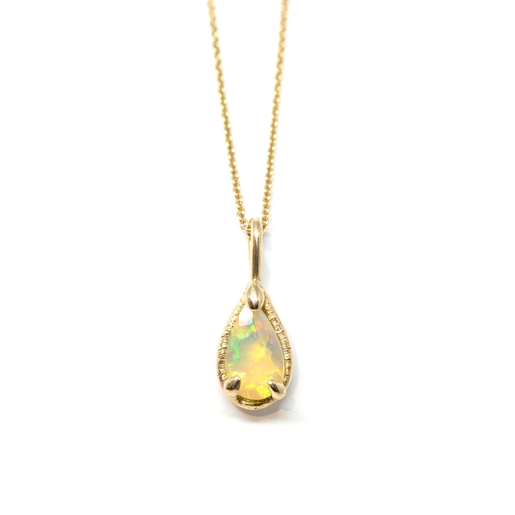 pear shape opal pendant in yellow gold made by the artisan jewelry designer sheena in montreal by the custom jewellery studio ruby mardi montreal on a white background