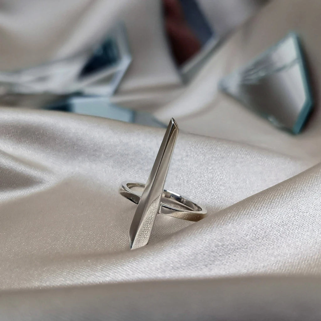 La bague Peak en vermeil du créateur de bijoux canadien Bena Jewelry, photographiée sur un tissu satiné. Bijou moderne et prédominant fabriqué à la main disponible chez Ruby Mardi, en ligne ou dans la Petite Italie de Montréal.