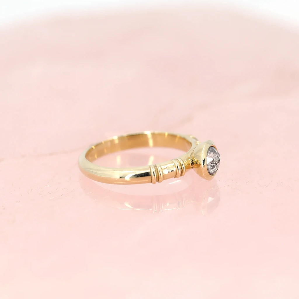 side view of yellow gold designer engagement ring with rose cut salt and pepper diamond bespoke jewellery design in montreal by boutique ruby mardi on pink background