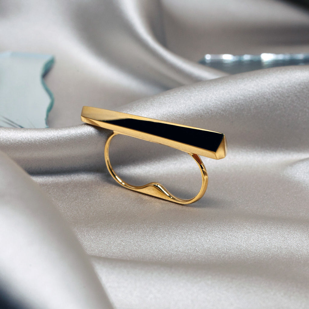 La bague Punch en or vermeil du créateur de bijoux canadien Bena Jewelry, photographié en gros plan sur un tissu satiné. Bague pour deux doigts très confortable disponible chez Ruby Mardi, en ligne ou dans la Petite Italie de Montréal.