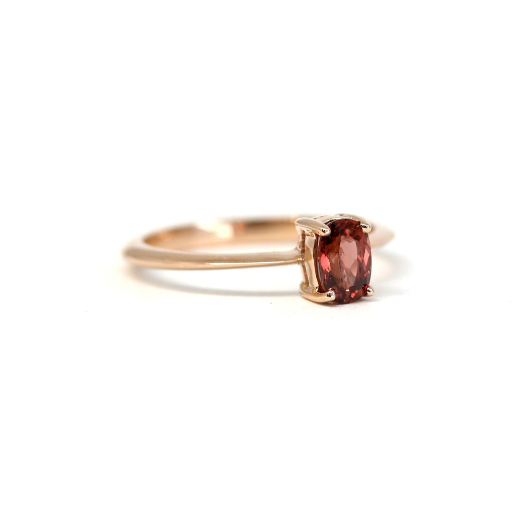 Side view of a rose gold solitaire ring with a cushion Malaya Garnet. An elegant and simple engagement ring that will stack easily with any wedding band.
