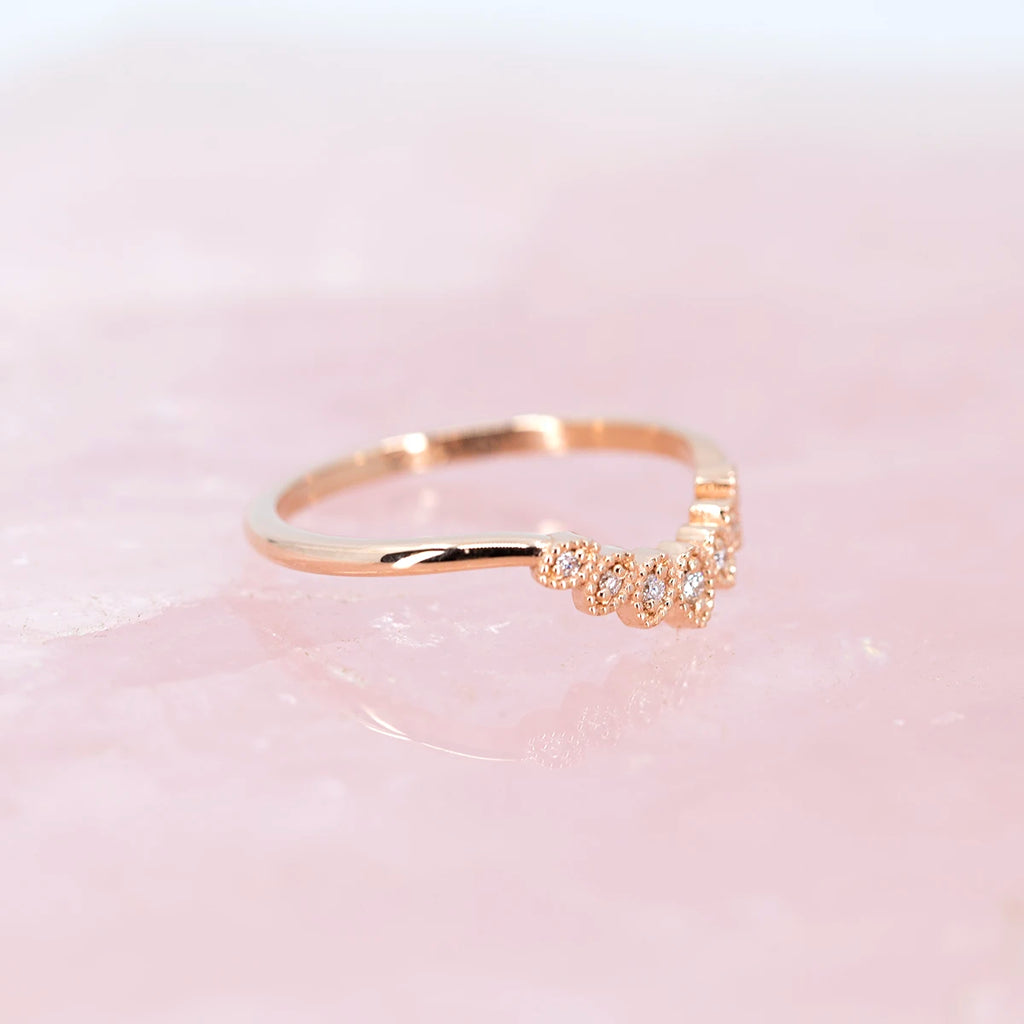 side view of rose gold wedding band milgrain vintage look dainty matching wedding band with engagement ring by ruby mardi jeweler on pink background