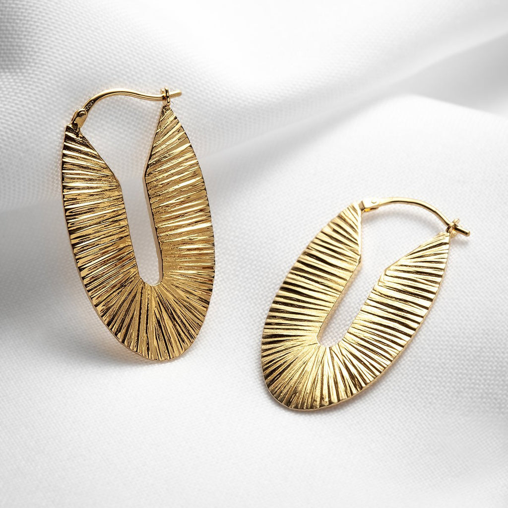 Large and chunky oval textured gold vermeil hoops handmade in Montreal by Veronique Roy JWLS. Available at jewelry store Ruby Mardi, in Little Italy.