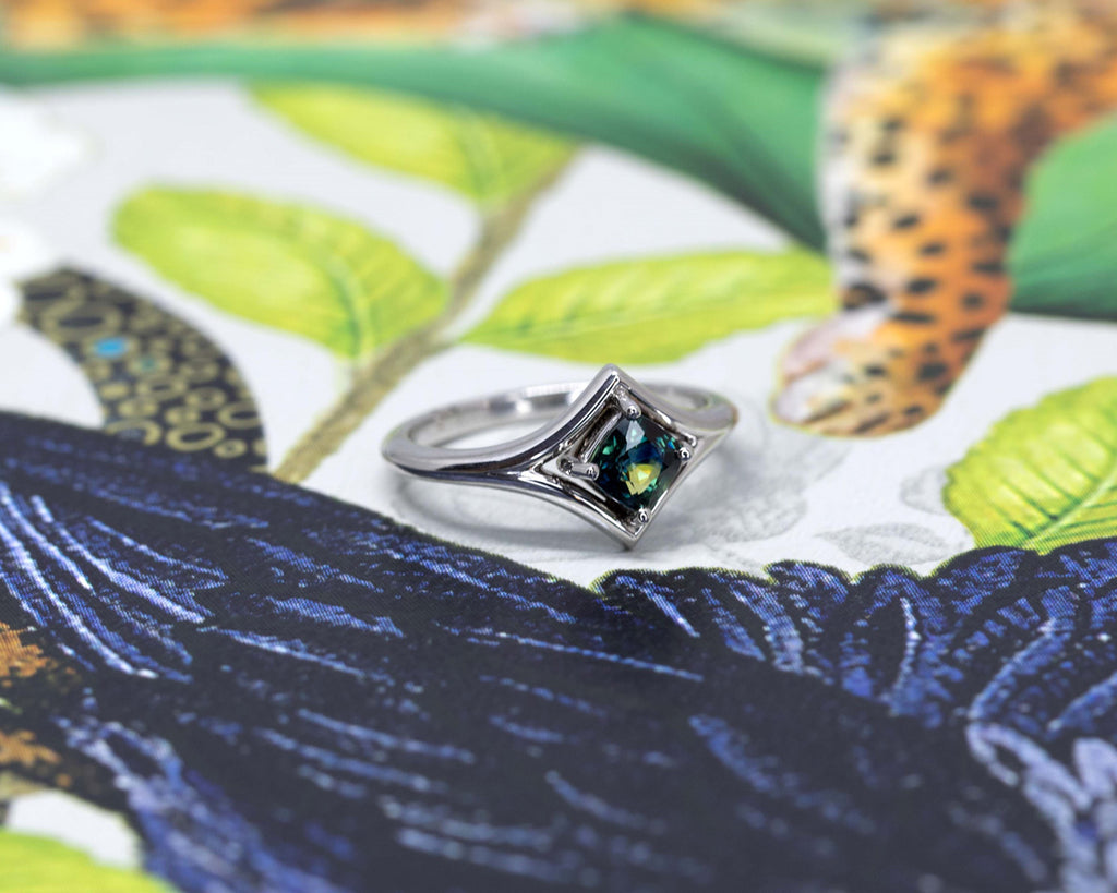 Modern gender neutral engagement ring or statement ring handmade in Montreal by designer Bena Jewelry and featuring an amazing bicolour sapphire in hues of dark blue and yellow. More fancy jewelry available at jewelry store Ruby Mardi.
