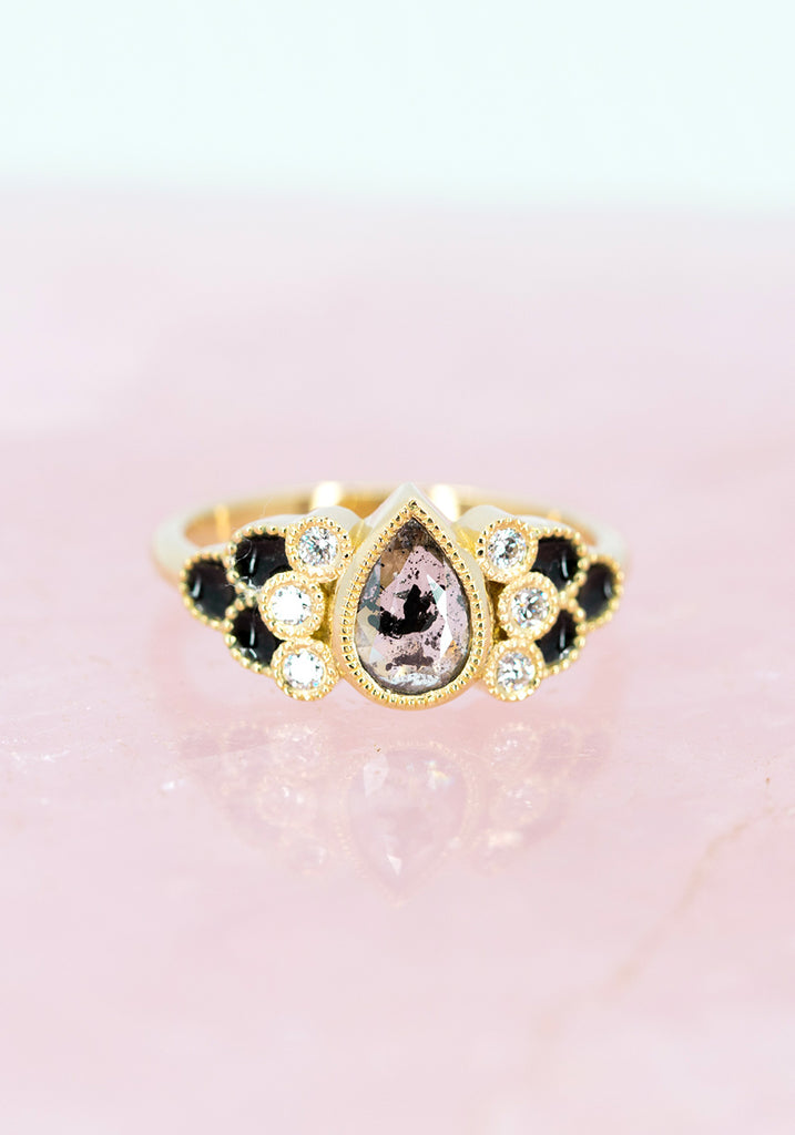 front view of pear shape rose cut diamond salt and pepper and enamel custom engagement ring made in montreal ruby mardi on pink background