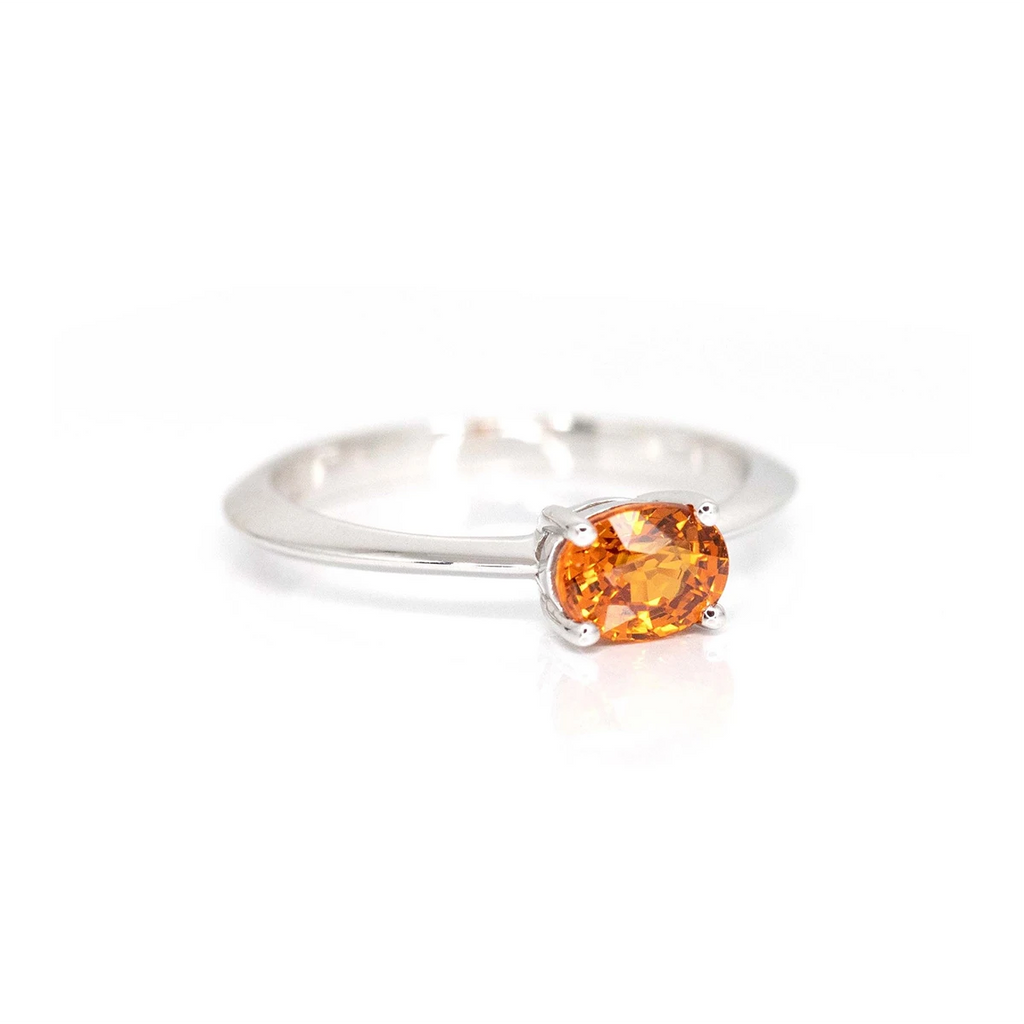 side view of oval shape orange garnet white gold rind made by the best jewelry designer in montreal boutique ruby mardi montreal gems broker edgy minimalist jewels on a with background