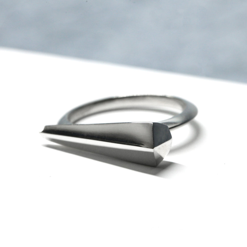 Spine ring in sterling silver by Bena Jewelry seen on a white background. Unisex piece that harnesses the radiance of angular shapes and power of light at play. Find it at our online store or in Montreal’s Little Italy.