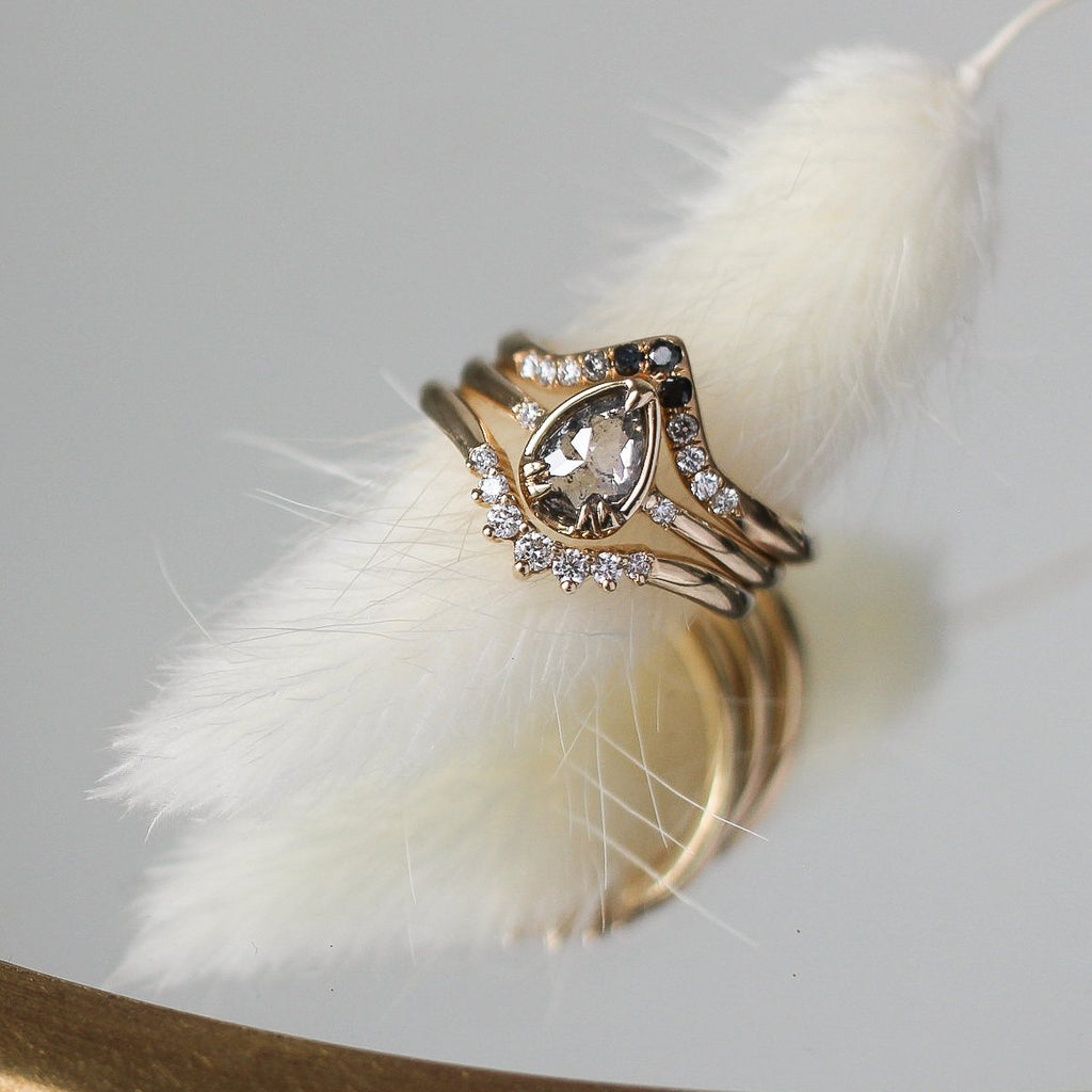 Close-up of stunning hand-crafted jewelry by Toronto designer Yuliya Chorna, available at Montreal's Little Italy fine jewelry store Ruby Mardi. An engagement ring in yellow gold with salt-and-pepper diamonds, as well as two bezels with diamonds.