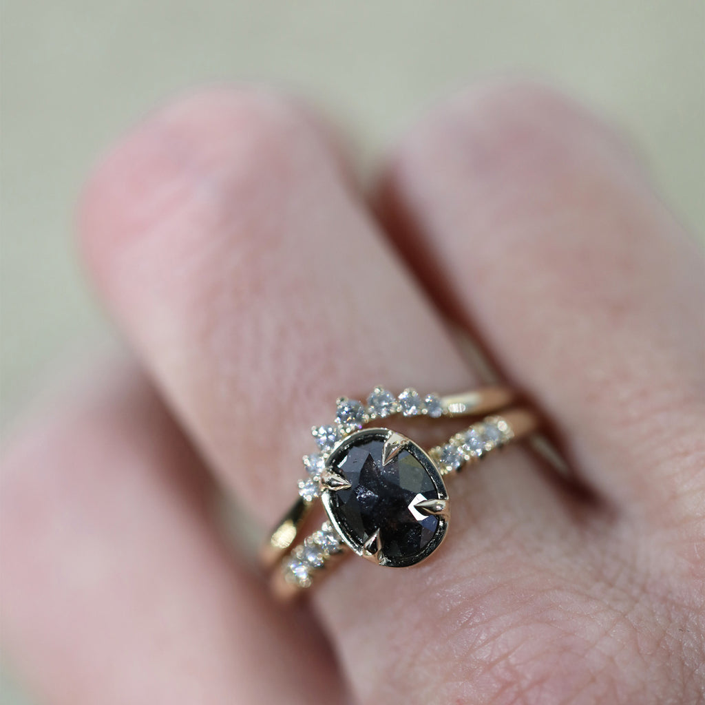 Sahara diamond band stacked with an engagement ring featuring an oval shape black diamond, handmade by Yuliya Chorna in Toronto. Here worn on a hand. Available at Ruby Mardi, a high end jewelry store in Montreal’s Little Italy.