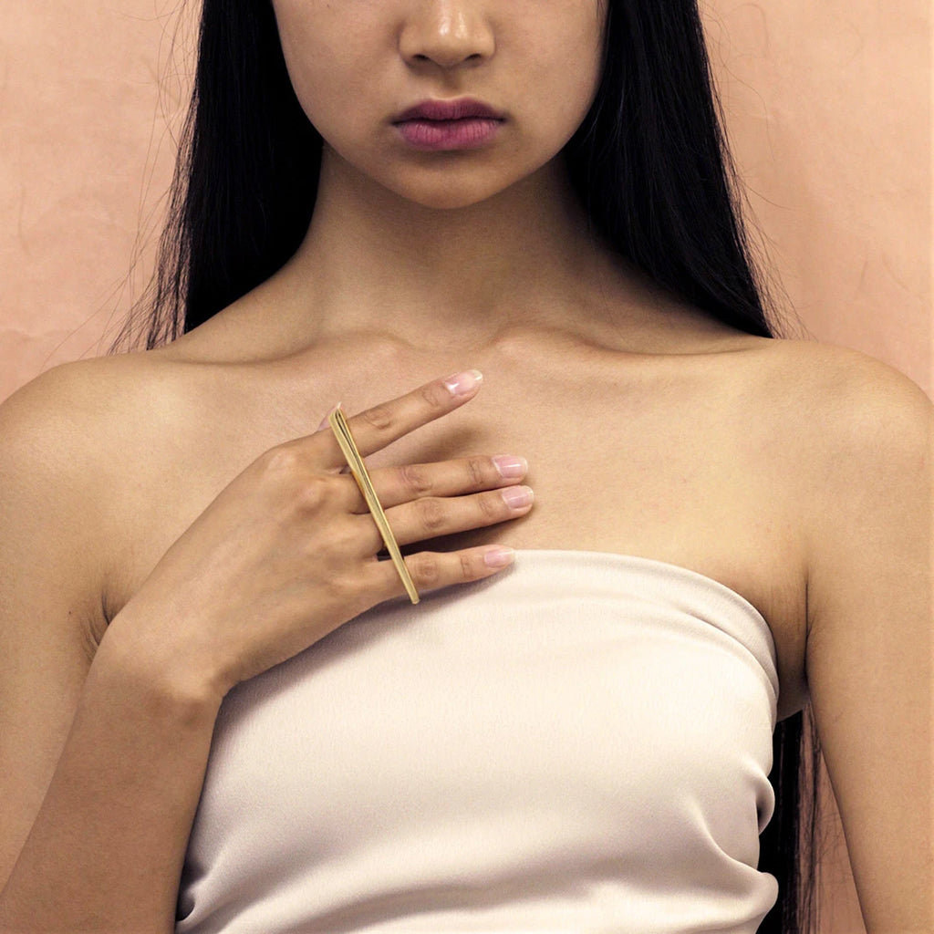 An asiatic lady seen from front wears a modern statement ring designed in Montreal by Bena Jewelry and available at concept store and fine jewelry gallery Ruby Mardi in Little Italy.
