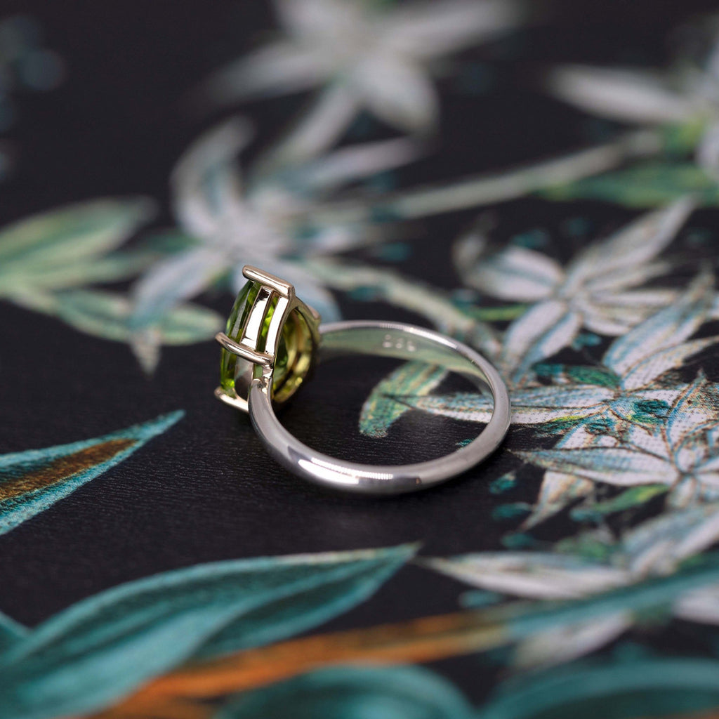 Huge peridot green gemstone statement ring on a wallpaper photographed in close-up. Ready-to-wear fashion jewelry available online or at our concept store in Montreal's Little Italy, along with the work of other talented jewelry designers. 
