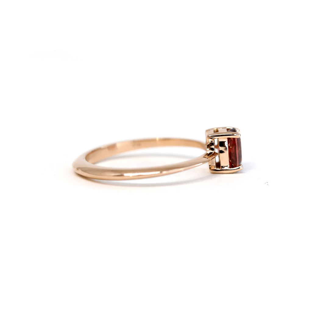 Side view of solitaire ring in rose gold with a red Malaya garnet. Find it at Ruby Mardi, the only fine jewelry gallery in Montreal.